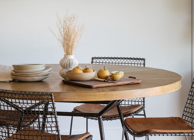 Photo of modern wooden table with wire chairs and vintage ceramics. We rent our vintage. 